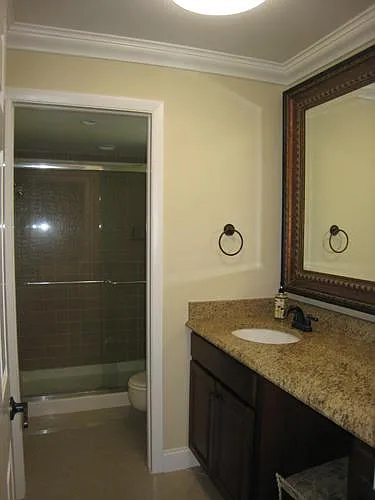 view of master bathroom with large granite vanity and shower