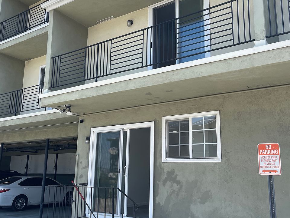 Exterior of apartment with balcony and sliding glass door entrance next to the kitchen