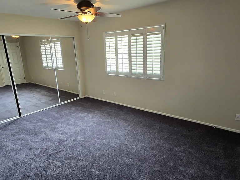 Master bedroom with wall-to-wall mirrored closet. Carpet color is Steel Gray