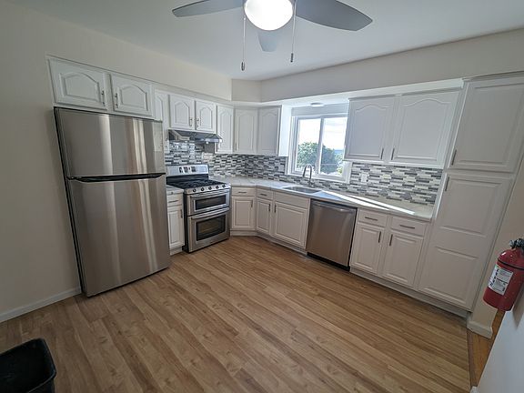 Newly renovated kitchen with brand new refrigerator, dishwasher, and over range hood.