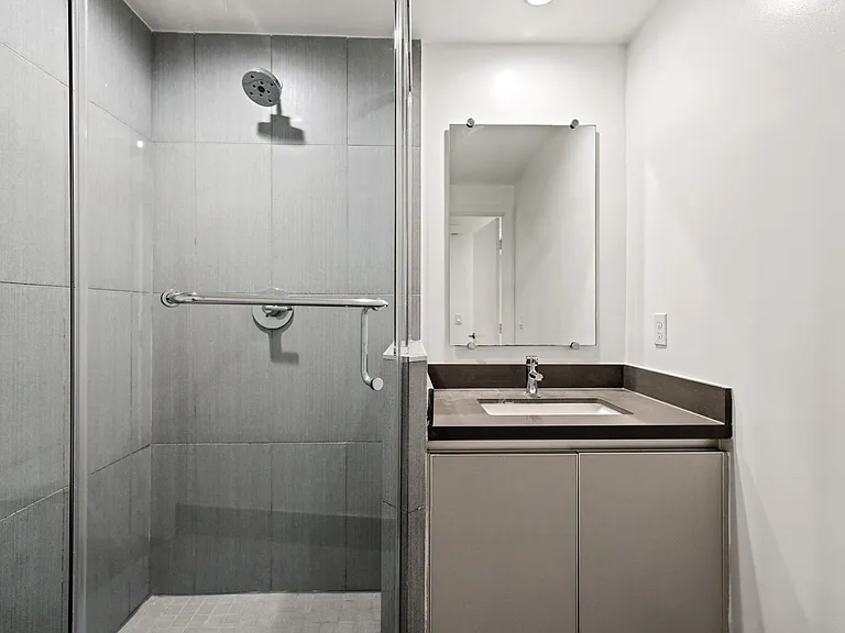 Bathroom with a Stand-Up Shower with Glass Door and Cabinet Storage