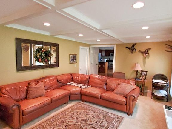 Family room from built in bookshelves. Wide doorway to kitchen with bathroom/laundry room on right