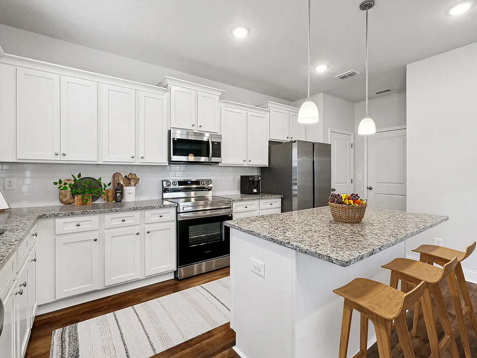 Spacious kitchen with an island, ample storage, and stainless steel appliances.