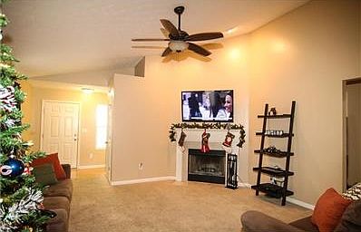 Large open concept living space from a different angle showing the fireplace.  9 foot ceilings, fresh paint, and plush carpet.