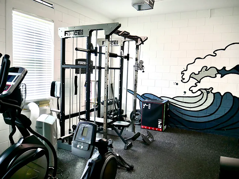 3rd car garage is a fully loaded gym with rowing, elliptical, smith machine, weights, television, air conditioner, etc.
