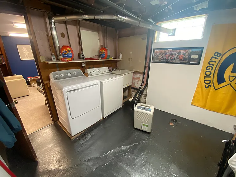 Laundry room with sink, washer, and newer clothes dryer.