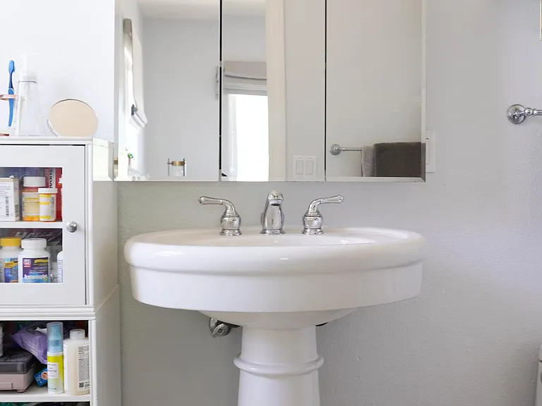 primary bathroom with pedestal sink, combo shower and bathtub, copper lighting