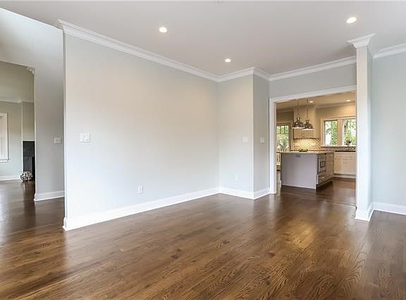 Dining room with view of the hallway and living room on the left, kitchen on the right.