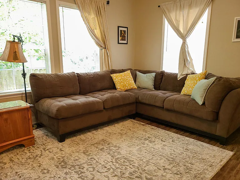 A very comfy couch to relax on and enjoy the large television and time together in an open space.