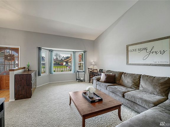 Living room off entry w/ vaulted ceilings & bay windows.