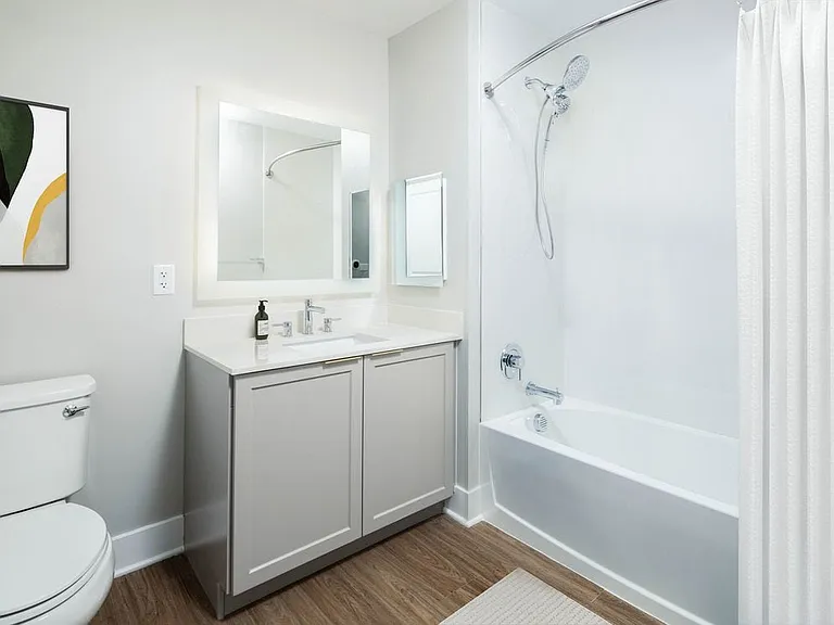 Signature Collection bath with white quartz countertop, backsplash, and hard surface flooring