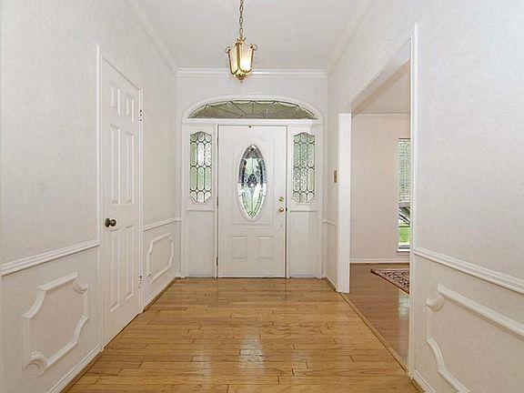 The walls have decorative moldings and the foyer opens to the formal dining room (or could be living room).