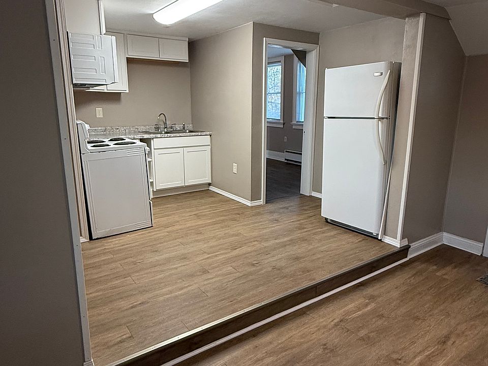 Living room area open to the kitchen and kitchenette. New paint, floors, and kitchen cabinets.