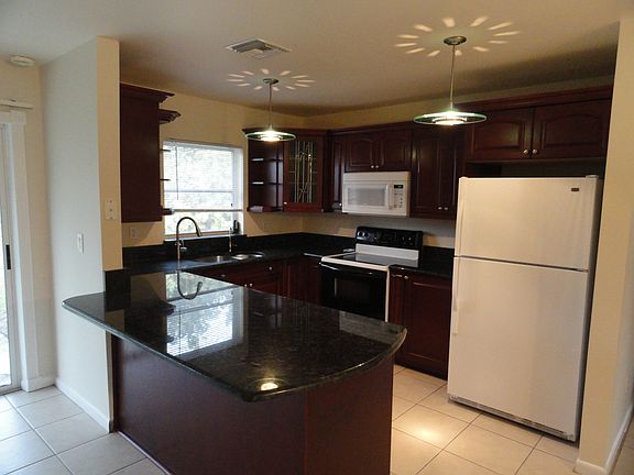 Custom granite kitchen. Pull out shelves. New dishwasher. Almost new refrigerator and stove. View of the large, fenced back yard.