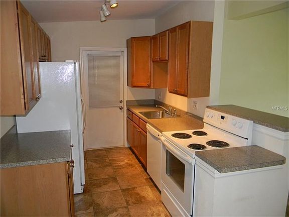 Kitchen with solid wood cabinets, dishwasher range and refrigerator.