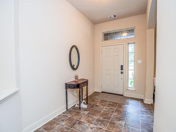 Tile entry, art niche thick baseboards and a wide formal foyer welcome guests.