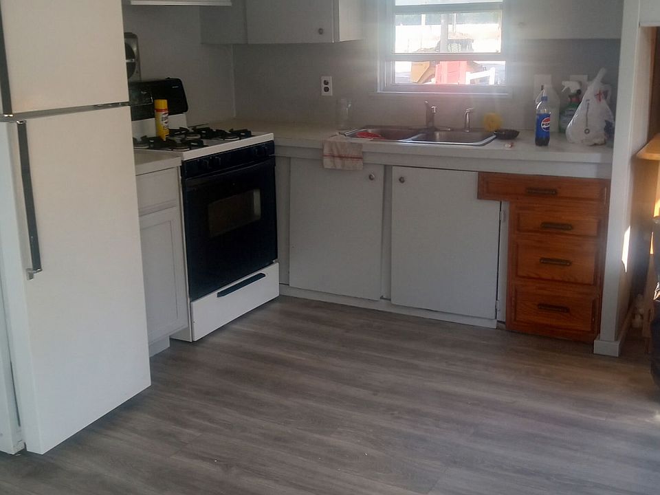 Roomy kitchen with stove and refrigerator.
