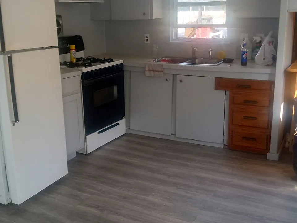 Roomy kitchen with stove and refrigerator.
