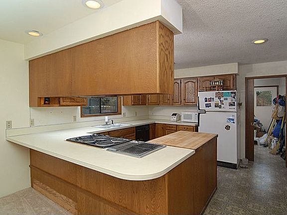 Open kitchen has a new stove and lots of storage and counter space.