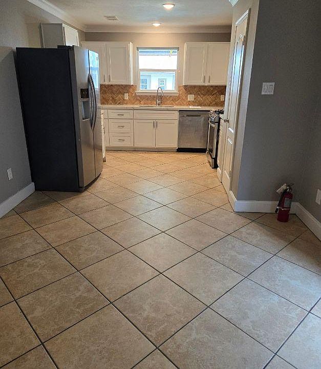 Kitchen and living room combo with refrigerator, dishwasher, stove and microwave.