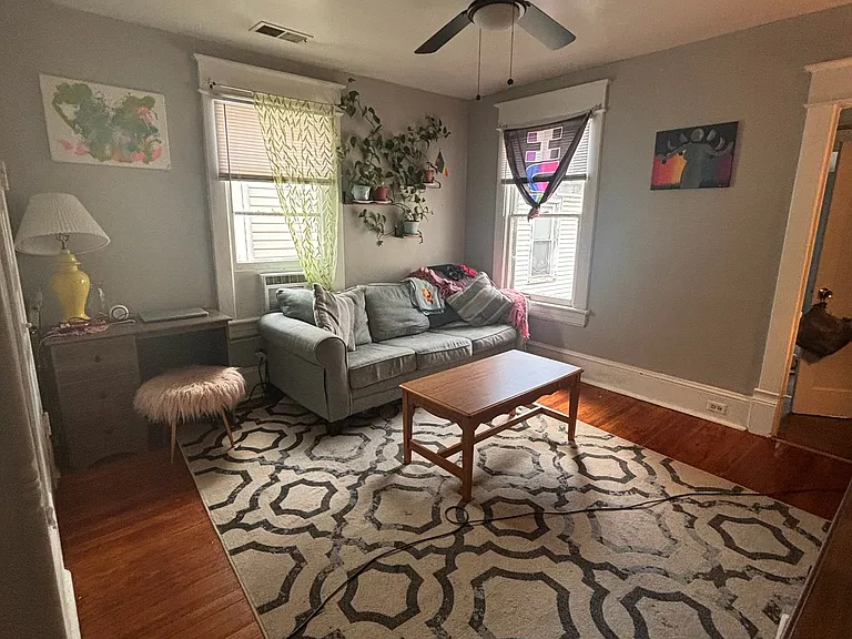 Living Room w/ Original Hardwood Floors and Designer Lighting. All Blinds provided by landlord. New Sherwin Williams Designer Paint.