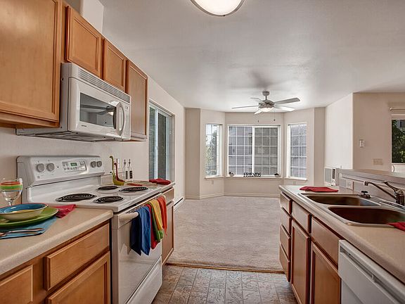 A kitchen with plenty of counter space, a breakfast bar, lots of cabinet storage space, and a view into the dining area