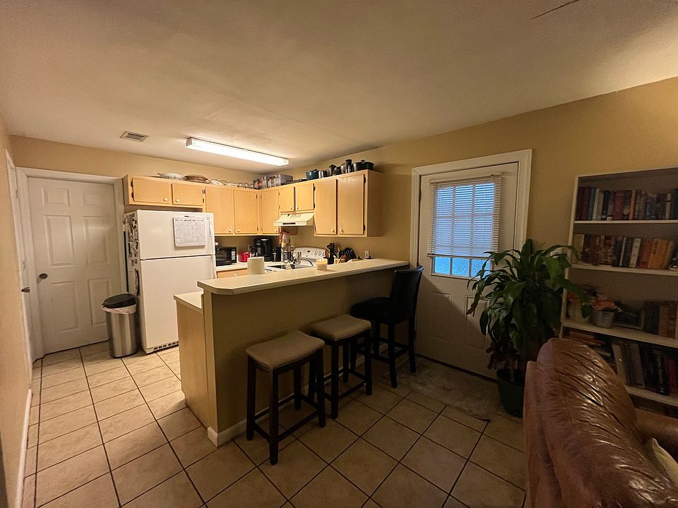Living room moves into the kitchen, with side door leading out to patio and outdoor storage unit