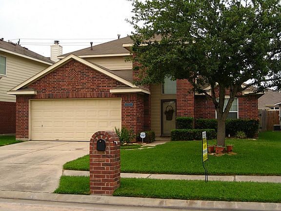 Lovely landscaped from yard with shade tree.