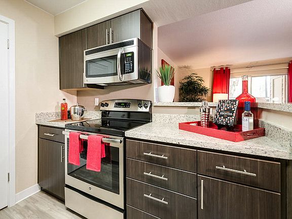 Staged kitchen with stainless steel appliances and quartz countertops.