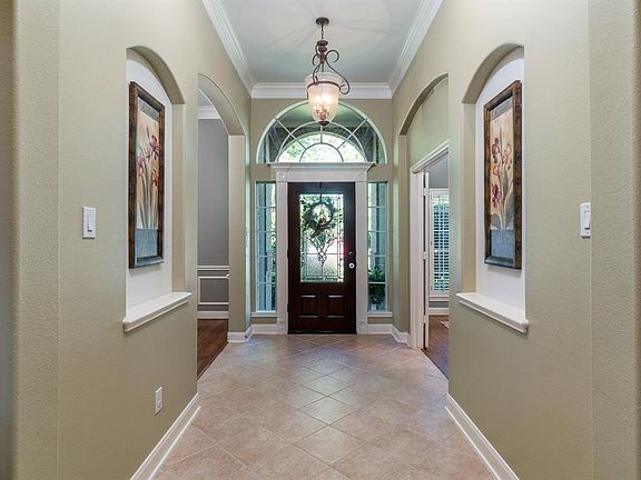 Could you find a more welcoming entryway? Architectural details including arched art niches, walkways and an arched window over a pretty leaded glass door that allows the natural light to flow into this space!