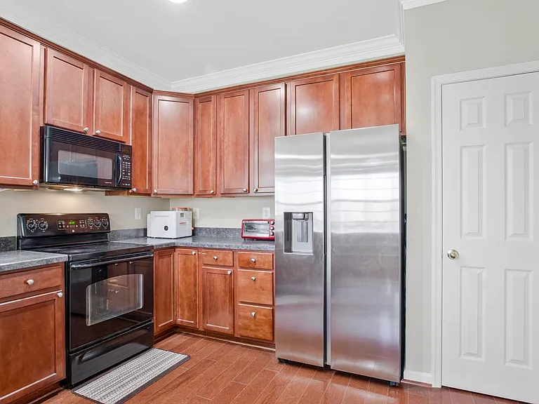 Clean lines, rich wood cabinetry, granite countertops, and stainless steel appliances give this kitchen a polished, modern feel with plenty of warmth.