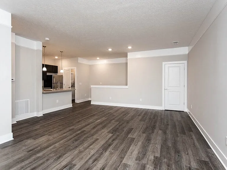 Dooley's Orchard unit showing a living room with wooden flooring and white walls.