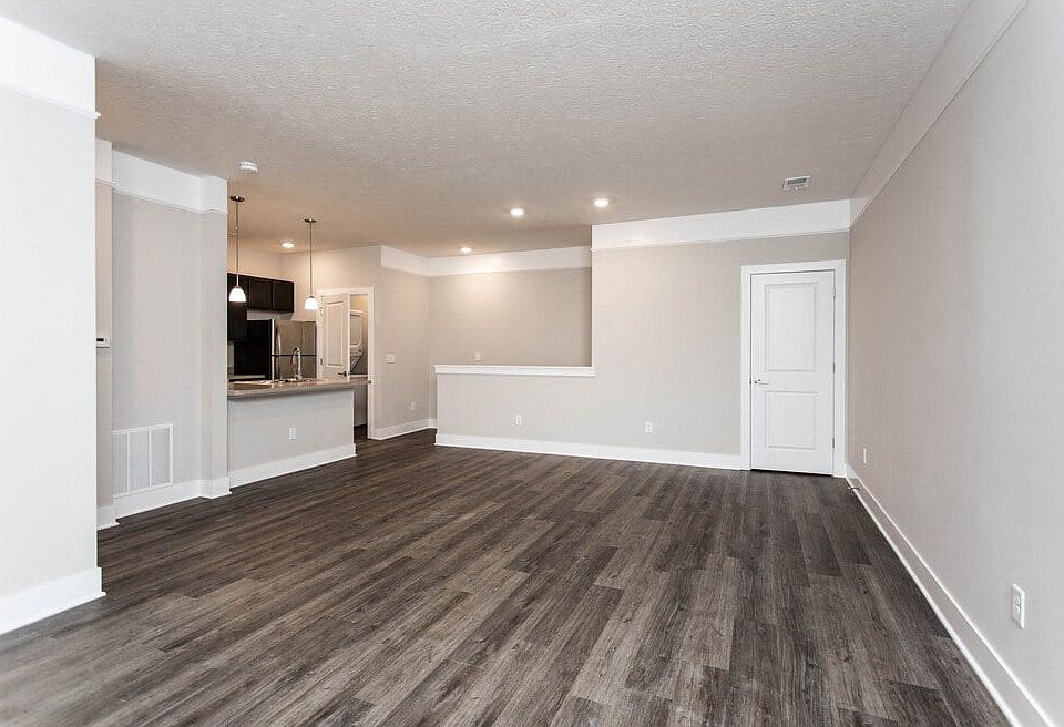 Dooley's Orchard unit showing a living room with wooden flooring and white walls.
