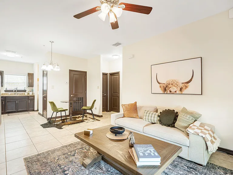 La Joya Apartments living room in Laredo, Texas, showcasing a couch, coffee table, and a ceiling fan for comfort