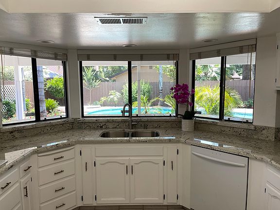Kitchen with new Refrigerator, countertop, kitchen sink, microwave, range hood air extractor and Trash compactor, etc.