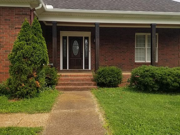 This is another photo of the front of the home. The sidewalk goes to the mailbox, and stepping stones lead around the house to the driveway. This lawn is about as flat as anyone could want.
