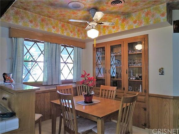 The dining area with built-in china cabinet and ceiling fan.