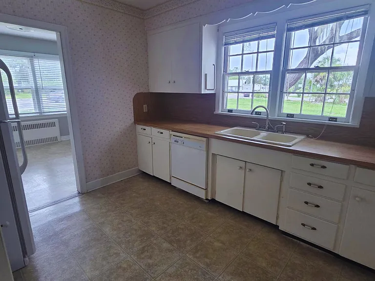 Spacious kitchen with ample cabinets, large windows, and built-in oven.