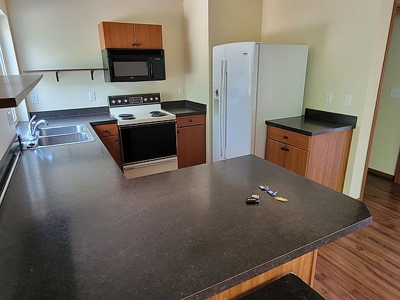 Kitchen with oven, fridge, microwave, and garbage disposal.