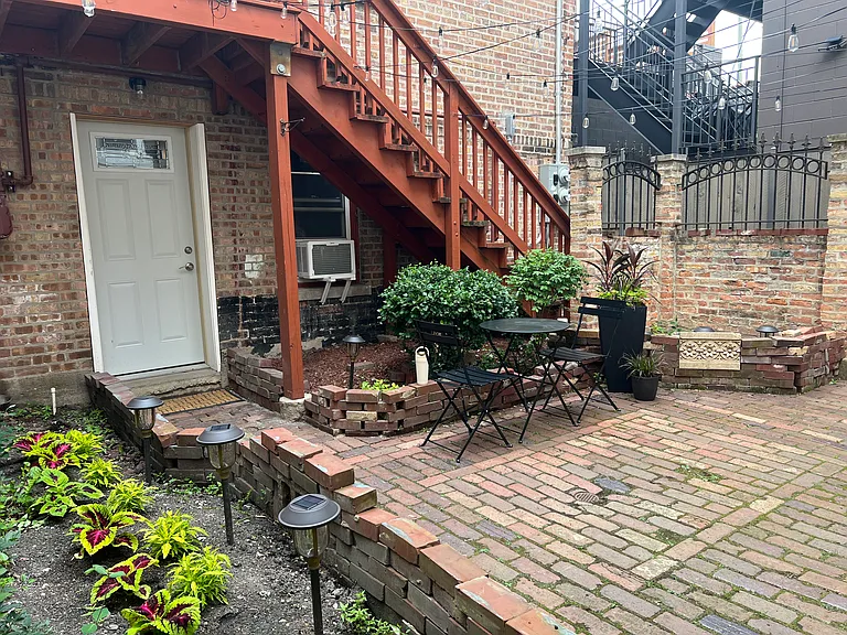 courtyard view of unit door during the daytime with summertime florals