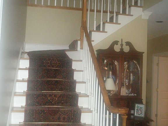 Inviting two story foyer with gorgeous wool runner up hardwood staircase