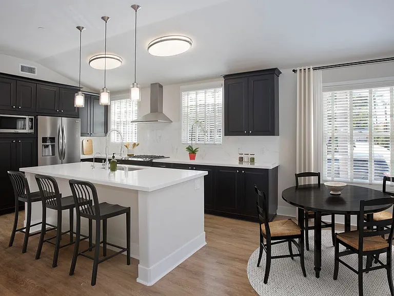 Kitchens with dark cabinetry, white quartz countertops, white tile backsplash, stainless steel appliances, and hard surface flooring