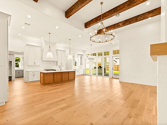 Open living space with warm hardwood floors and a full wall of windows