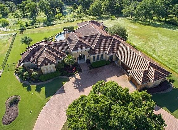 Circle paver stone driveway with beautiful, lush landscaping greet you as you arrive at 704 Cimarron Hills Trail.  Lush, green space with tributary of the San Gabriel behind outdoor patio living area on east side of home.