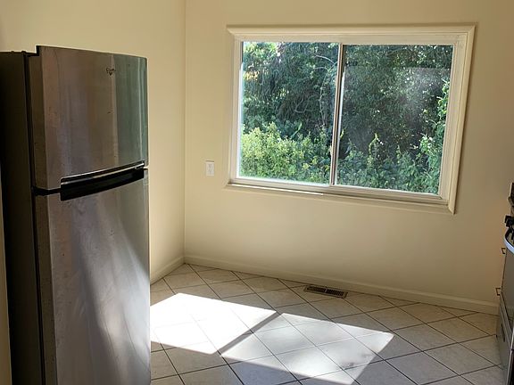 Stainless fridge, breakfast nook, new LED light fixture and tiled floor