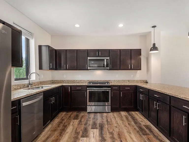 Kitchen with stainless steel appliances and quartz countertops.