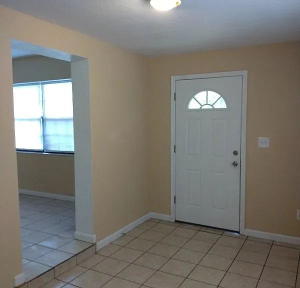 View from entry/mudroom or foyer of front door and glimpse into living room.