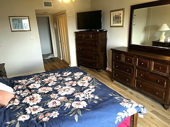Bedroom with king size bed, with 2 dresses, and TV