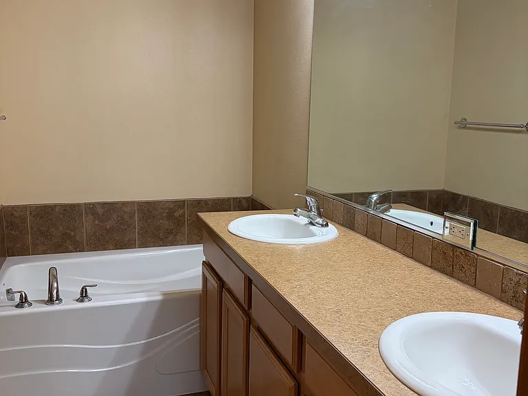 spacious master bathroom has double sink, tub, shower, walk in closet