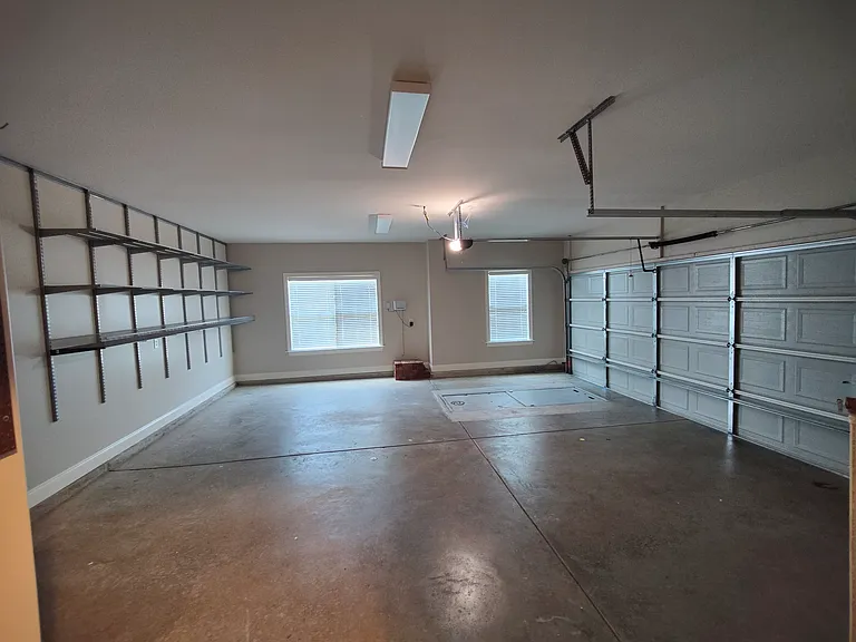 Two car garage with shelves.
